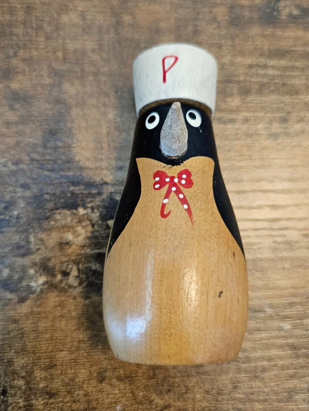 Vintage hand-painted wooden pepper shaker shaped like a penguin